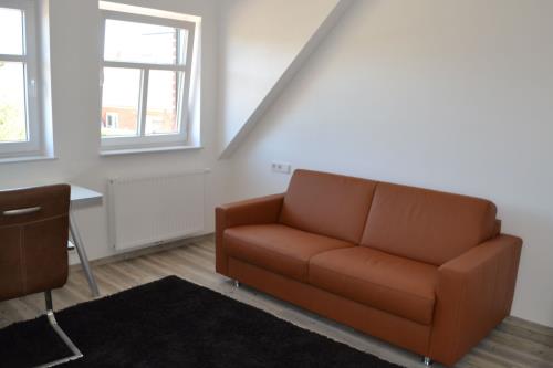Borkum Ferienwohnung Wellenklang - wohnzimmer mit sofa und schreibtisch