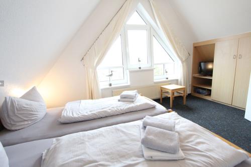 Langeoog Ferienhaus Karkpolder Residenz Haus 3 - Schlafzimmer 1 mit Sicht zum Schrank TV