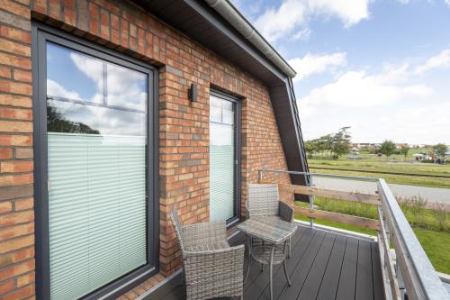 Langeoog Ferienhaus Villa Hafenkieker - Möbilierter Balkon Blick zum Spielplatz