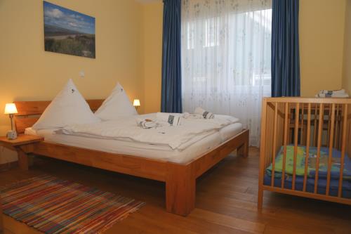 Spiekeroog Ferienwohnung Admiral - Wintergarten - großes Doppelschlafzimmer mit Kinderbett
